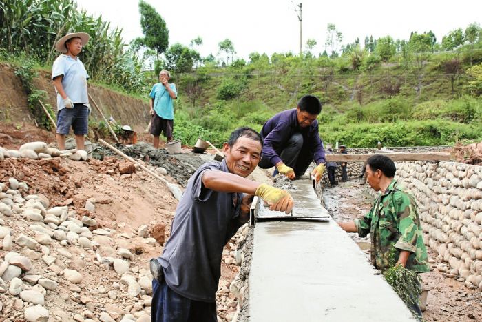 工人正在修建灌排两用渠。
