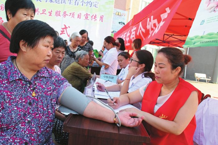 志愿者正为市民测量血压。
