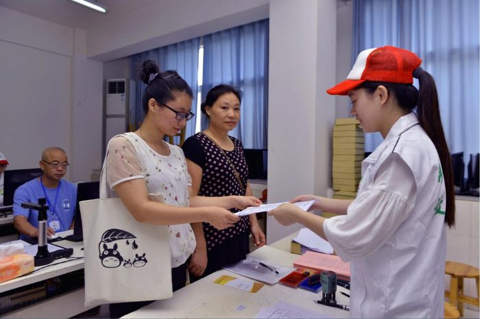 张蒋艳（右三）在志愿者帮助下顺利办结助学贷款业务。
