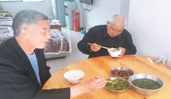 王安才（右）一日三餐胃口好，饮食清淡。
