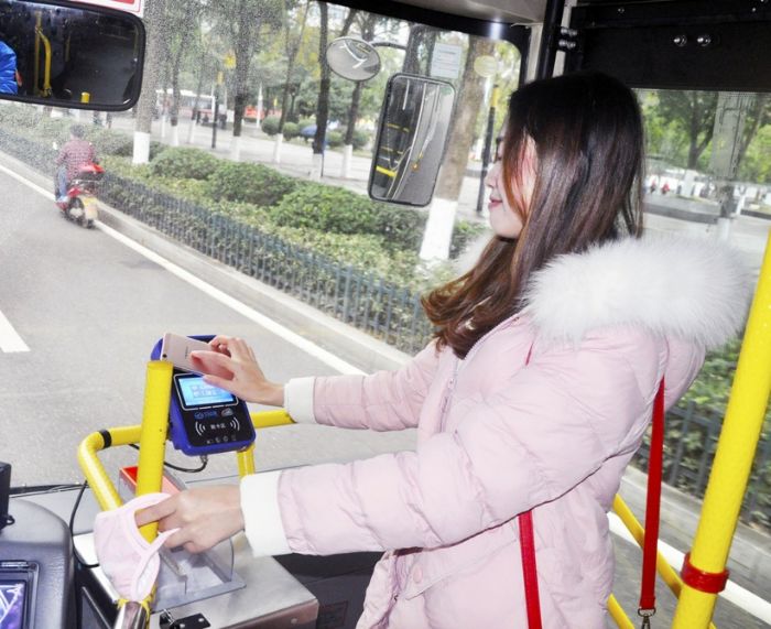 市民正在用手机扫码支付公交车费。
