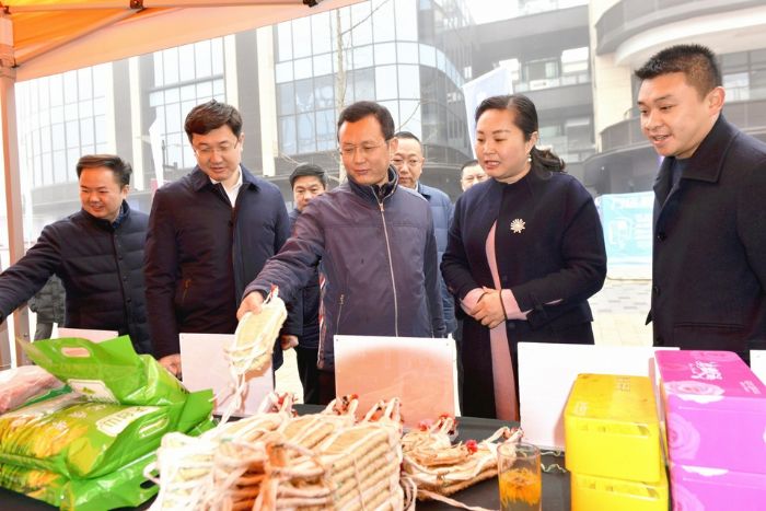 曾菁华、王志杰在卧佛镇电商展台前察看特色农产品展示。全媒体记者陈靖摄
