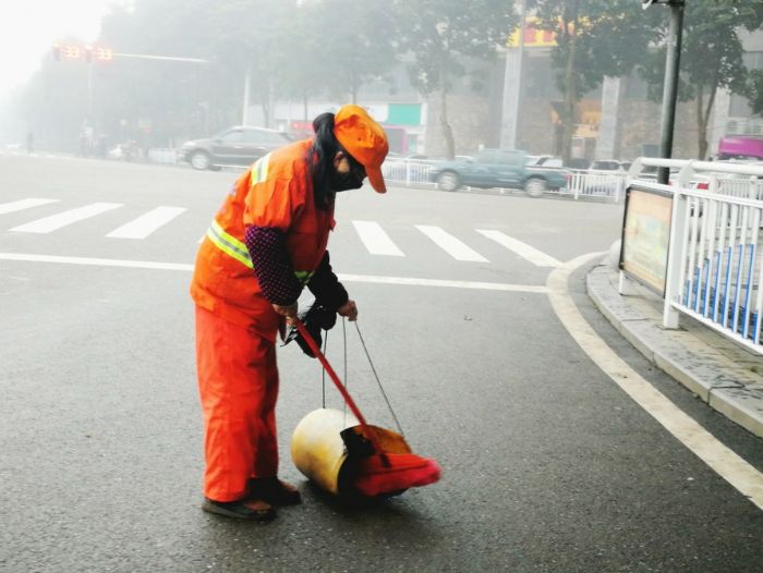　　在凉风垭广场旁，环卫工人正在清扫街道。
