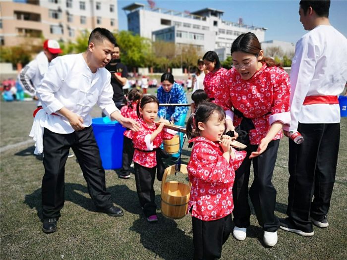 孩子与家长齐挑水。
