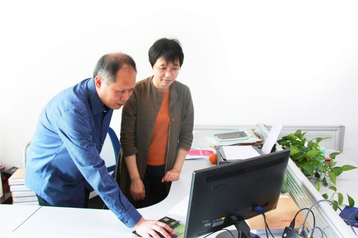 黄兴荣为同事讲解软件使用方法。
