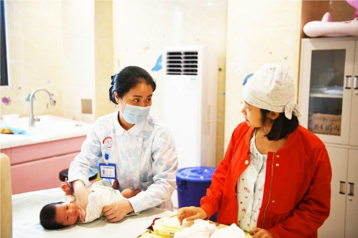 郑小勤（左）为“宝妈”讲解婴儿护理技巧。

