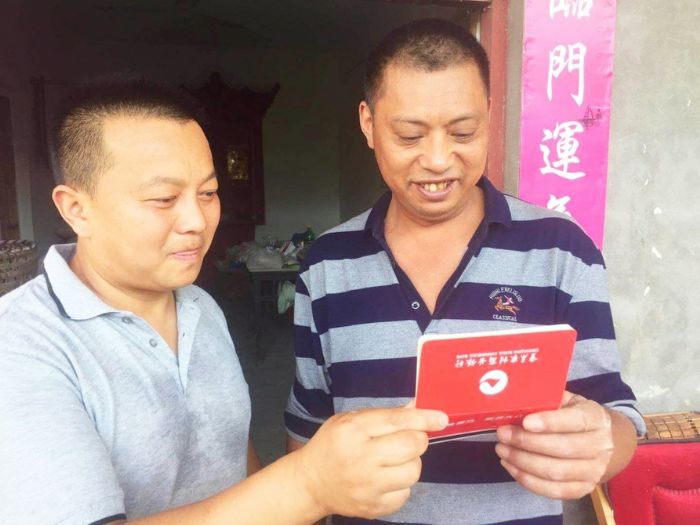 刘海生（左）看着村民杨建宗存折上不断上升的金额由衷地为他高兴。