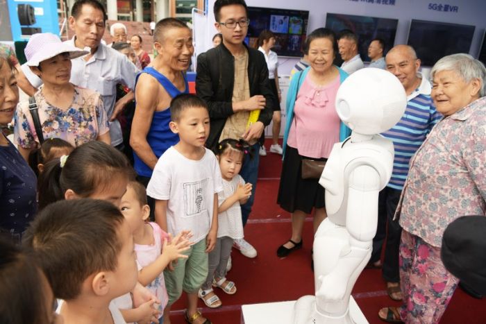 群众与5G智能机器人互动。
