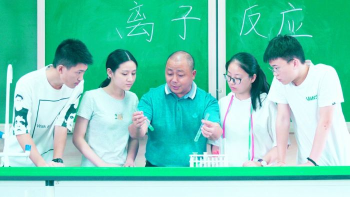 王建带领学生做化学实验。
