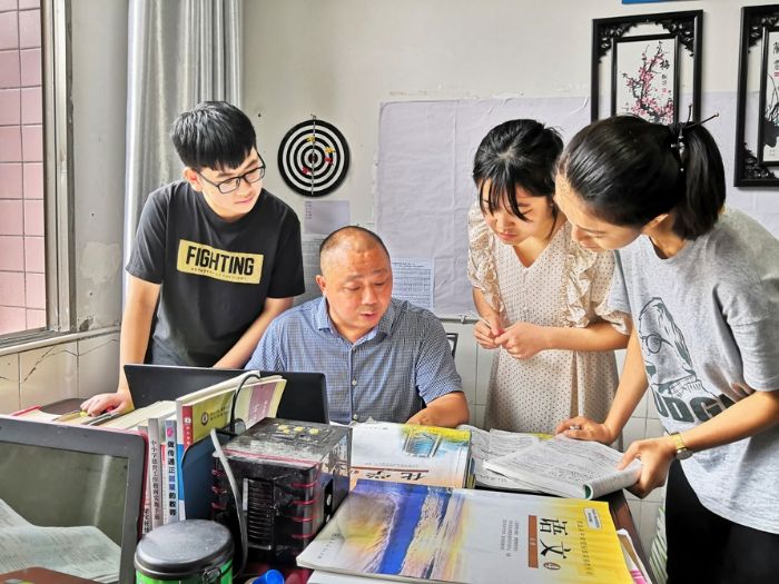 　　 王建在办公室辅导学生。
