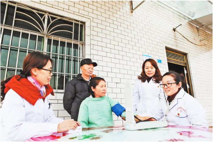 永川仙龙镇张家村，党员服务队医生为贫困患者测血压。
