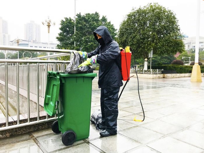 环卫工人给废弃口罩专用垃圾桶消毒。
