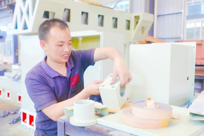 5月13日，在重庆市普创长顺机械有限公司生产车间，农民工正在组装磨床。
