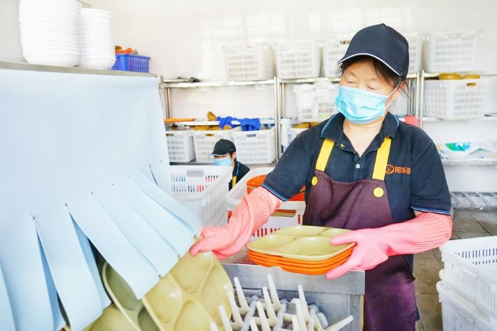 实验中学食堂师傅正在给餐具消毒。
