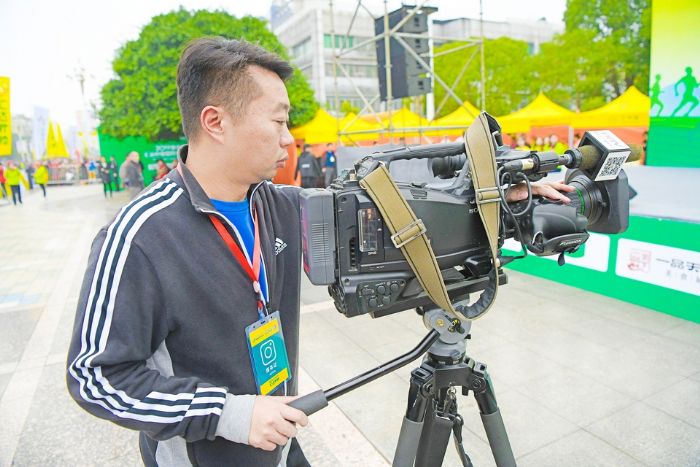 段东敏在潼南国际半程马拉松现场拍摄新闻。
