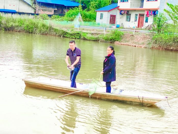 郭永彦在指导贫困户李风均给她的鱼塘消毒。
