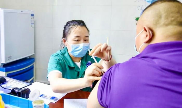 区中医院护士给群众接种重组新冠病毒疫苗。
