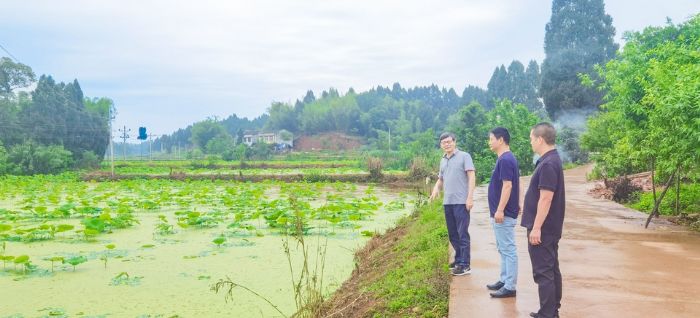 柏梓镇哑河村原第一书记王川（左）向新来的驻村队员介绍产业发展情况。
