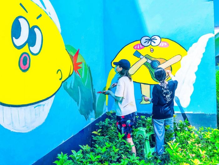 志愿者在柏梓镇南华宫公园举行墙绘创作。
