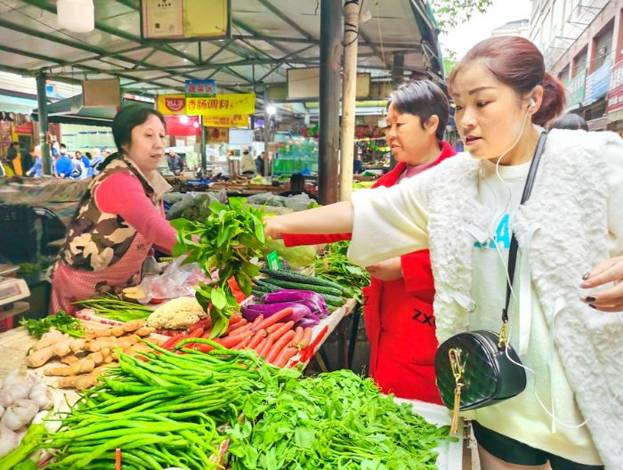 市民在菜市场购买蔬菜。
