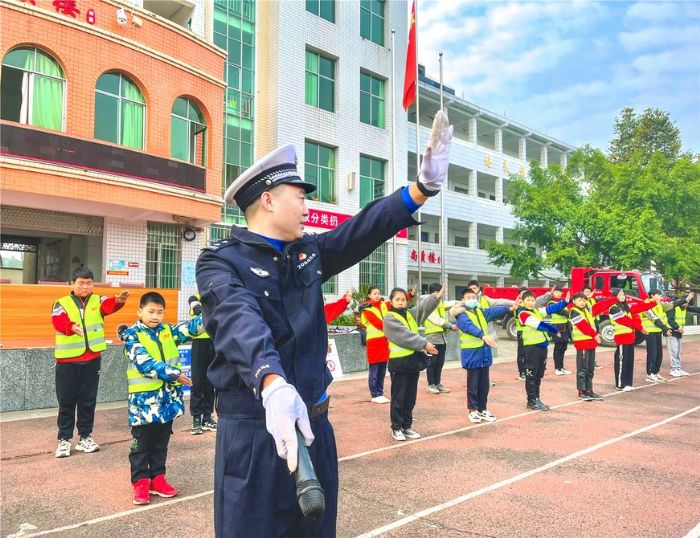 ▲孩子们在民警示范下认真学习交通手势。
