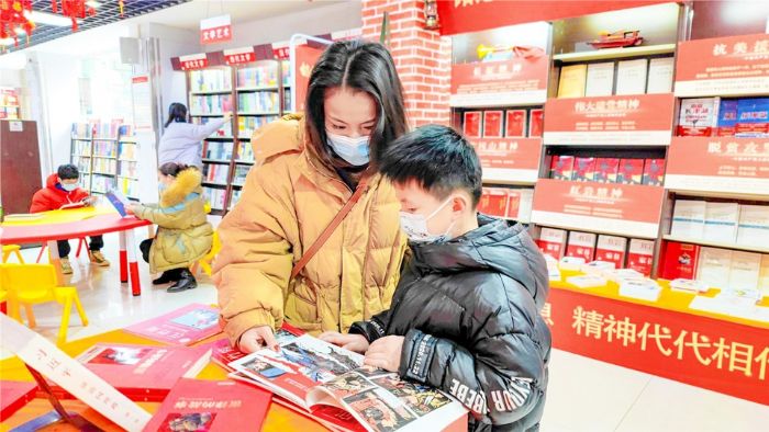 家长带孩子到新华书店学习党史，接受红色教育。

