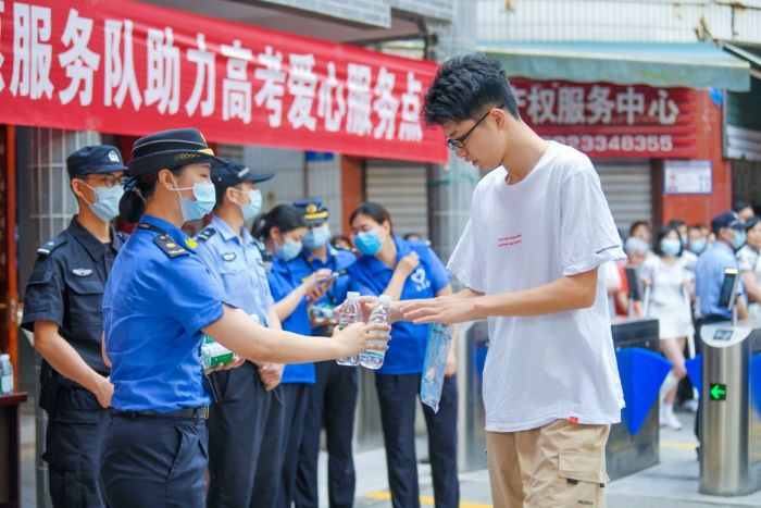 城管人员给考生送水。
