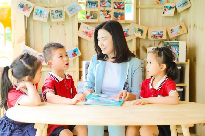 邓小芳和幼儿园的孩子一起读书。
