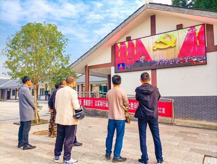 　　在大佛街道三村联建党群服务中心，群众在LED大屏前驻足观看开幕会直播。
