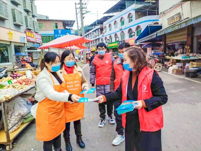 普法志愿者向居民发放宣传单。
