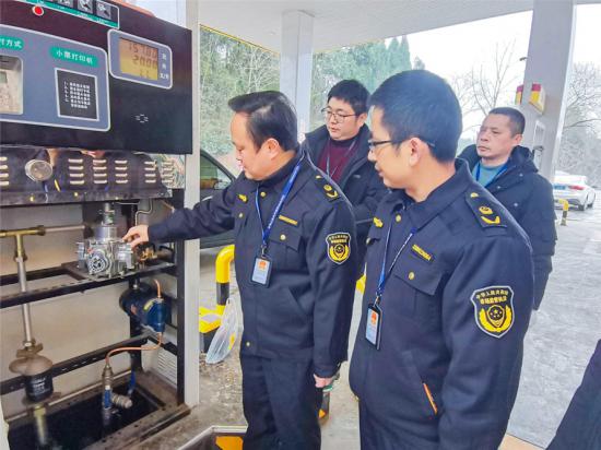 执法人员检查加油机铅封是否完好。