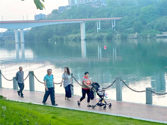 市民在涪江河畔的公园里散步。